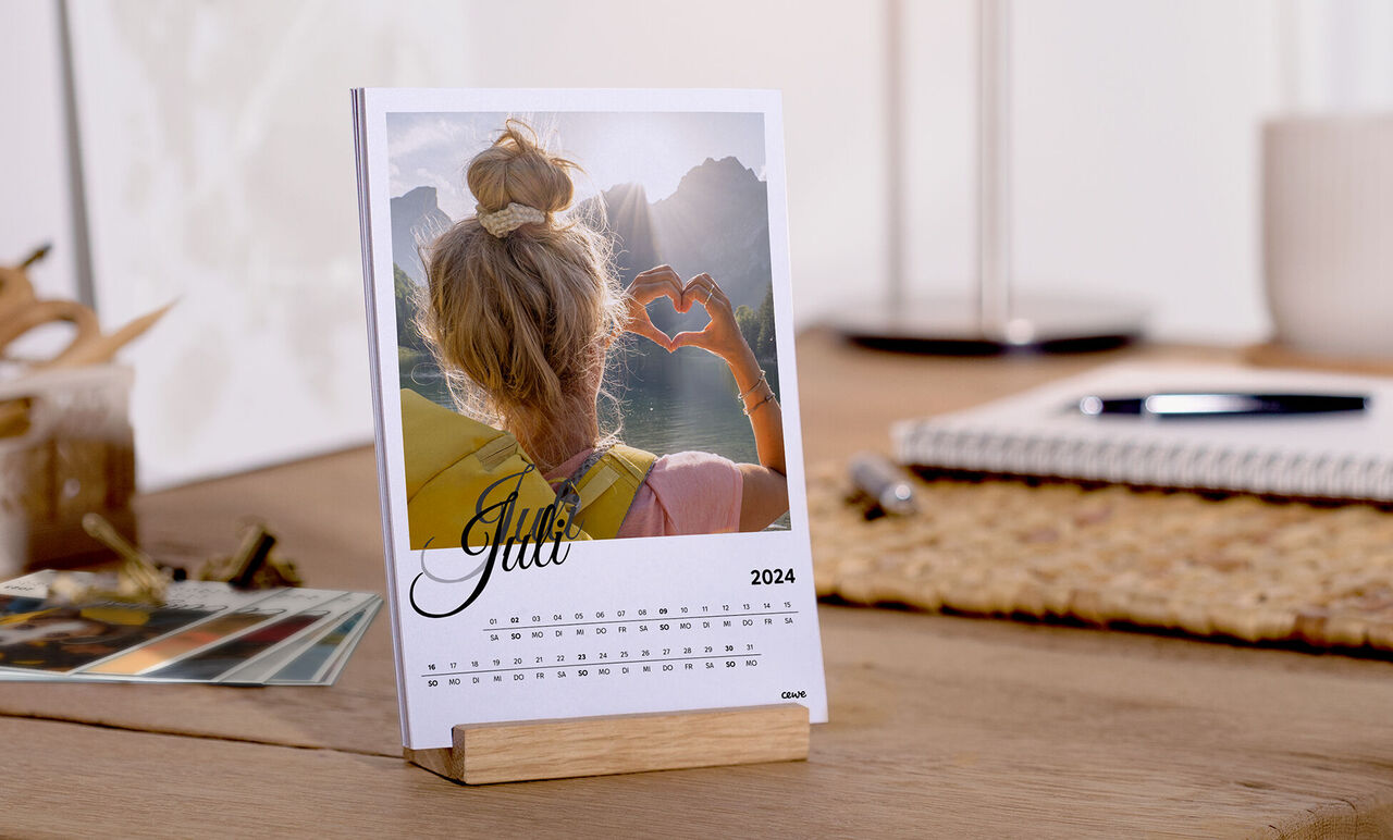 Gratis tafelkalender voor juni 2025 met een foto van iemand die een hart met de handen vormt.