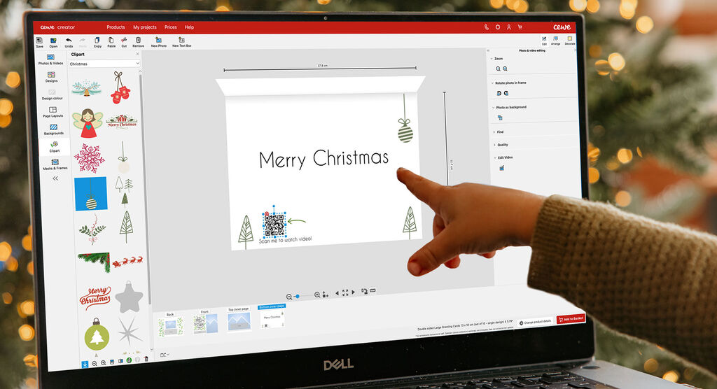 Iemand ontwerpt een digitale kerstkaart met elementen zoals kerstboom en lichtaccenten.