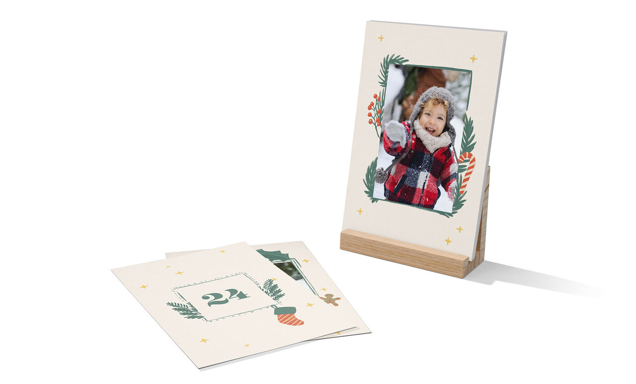 Een liefdevol ontworpen fotolijst gemaakt van 100% gerecycled papier met een feestelijk motief. Ernaast ligt een decoratievel met nummer 24.