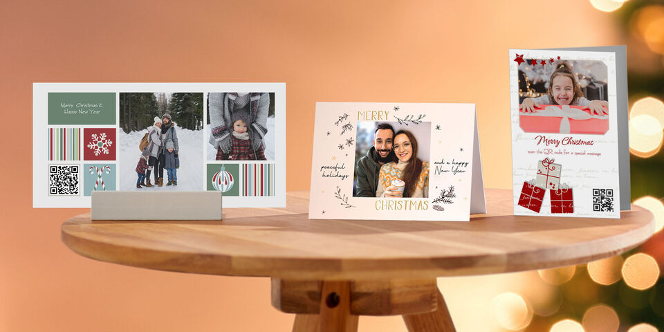 Drie prachtig ontworpen CEWE wenskaarten op een tafel, passend voor kerst, in diverse designs.